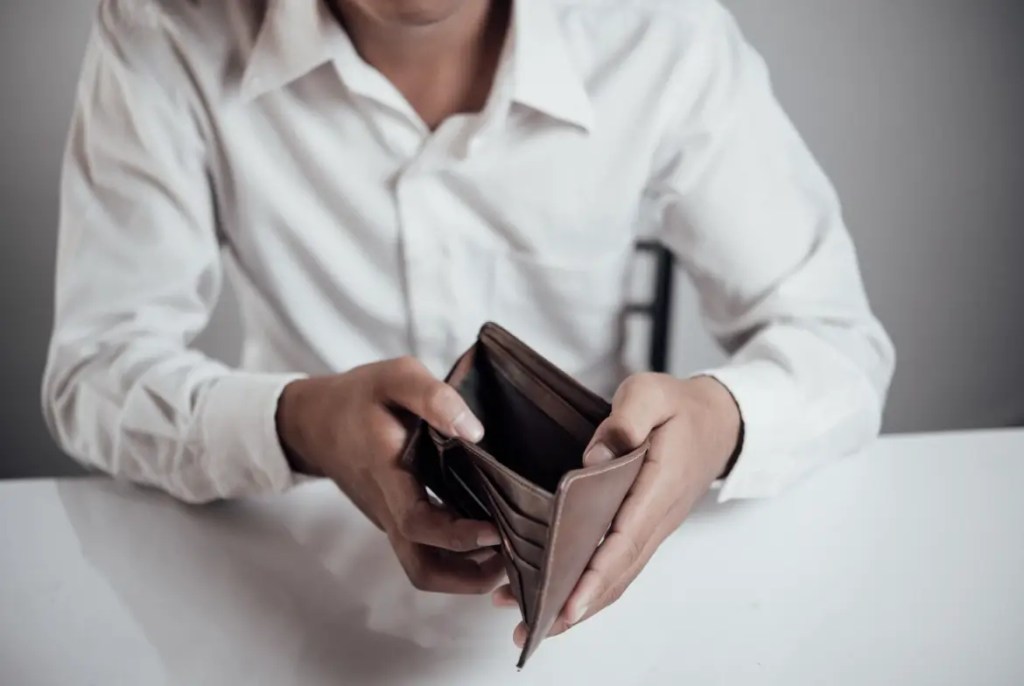 imagem de homem mostrando uma carteira de dinheiro vazia para falar sobre estar negativado