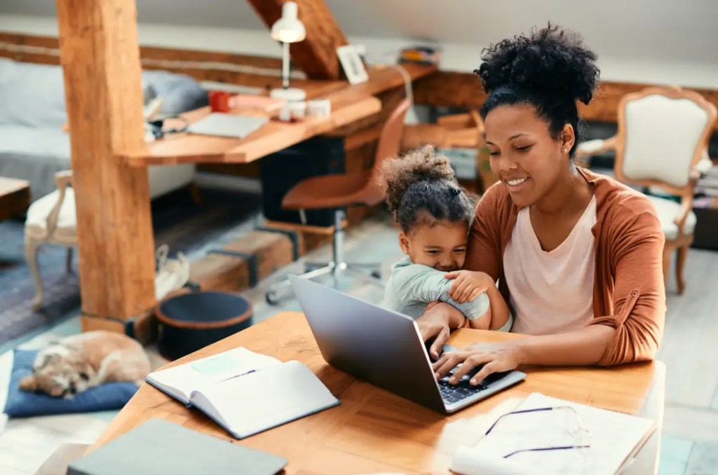 imagem de mulher trabalhando com criança no colo para falar sobre finanças para autônomos