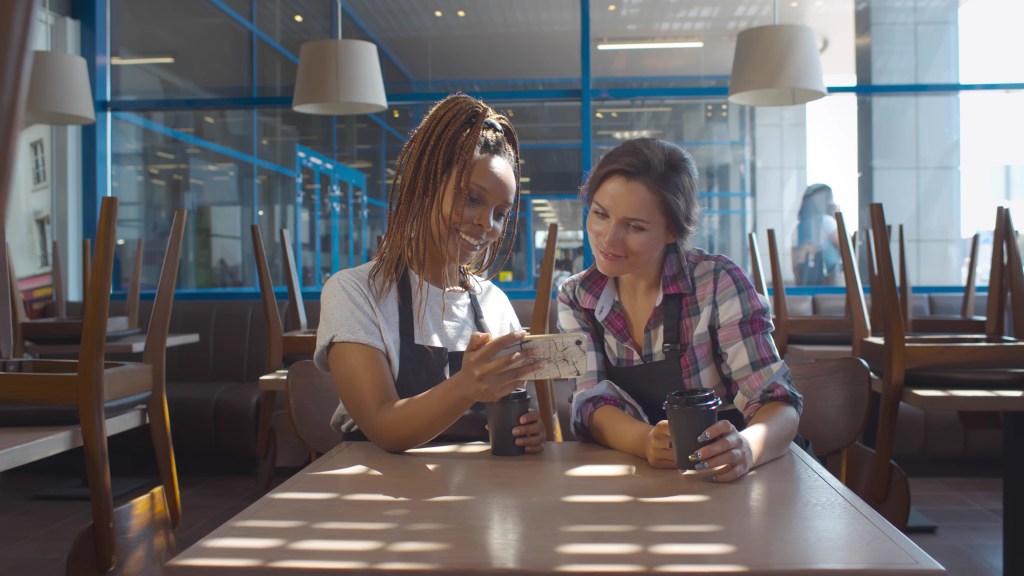 Duas mulheres com celular em mãos